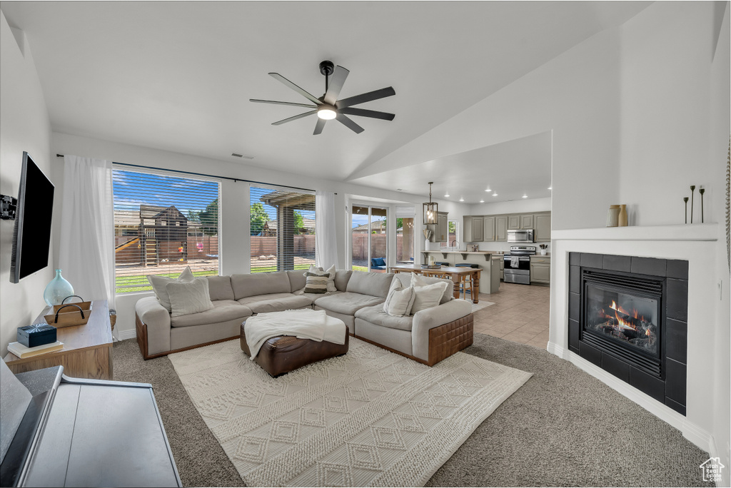Living room with ceiling fan, lofted ceiling, light carpet, a tile fireplace, and recessed lighting
