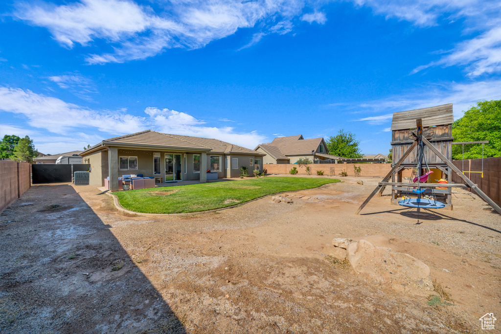 Fenced backyard featuring a patio area and a playground