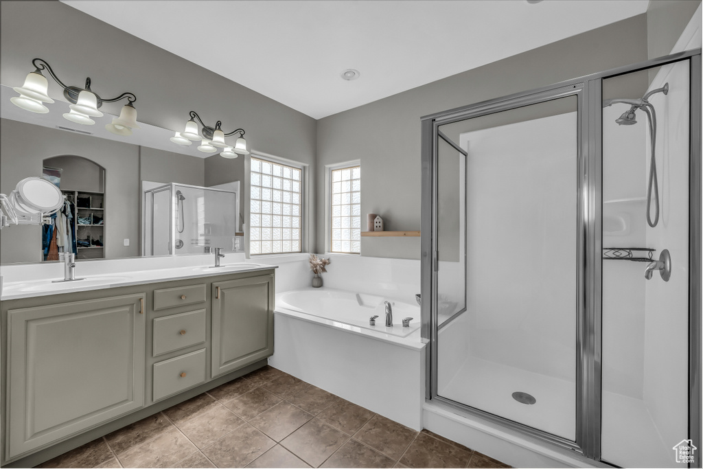 Bathroom with a stall shower, a garden tub, and double vanity