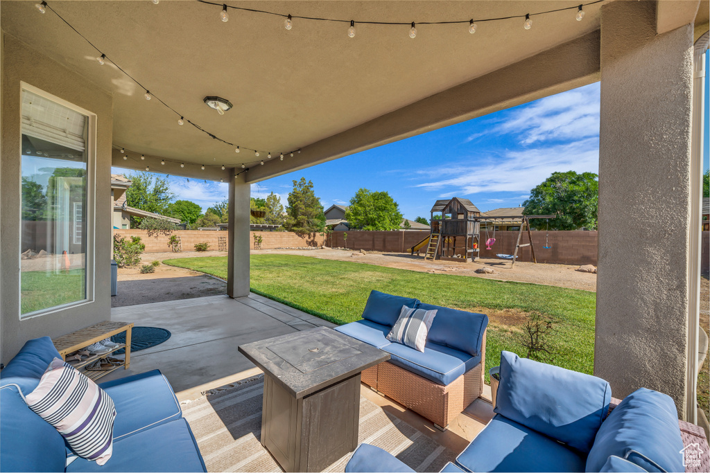 Fenced backyard featuring a patio, an outdoor hangout area, and a playground