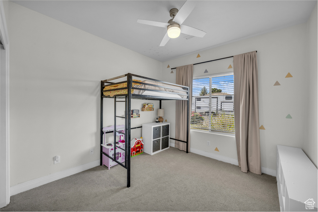 Unfurnished bedroom with light carpet and ceiling fan