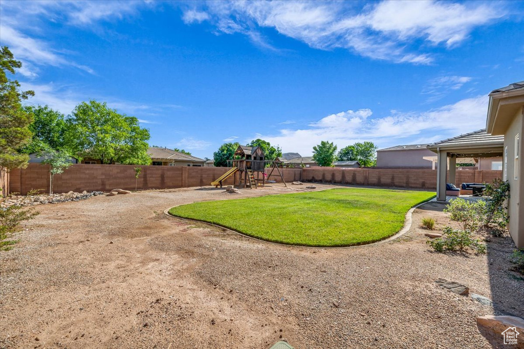 Fenced backyard with a playground and a patio area