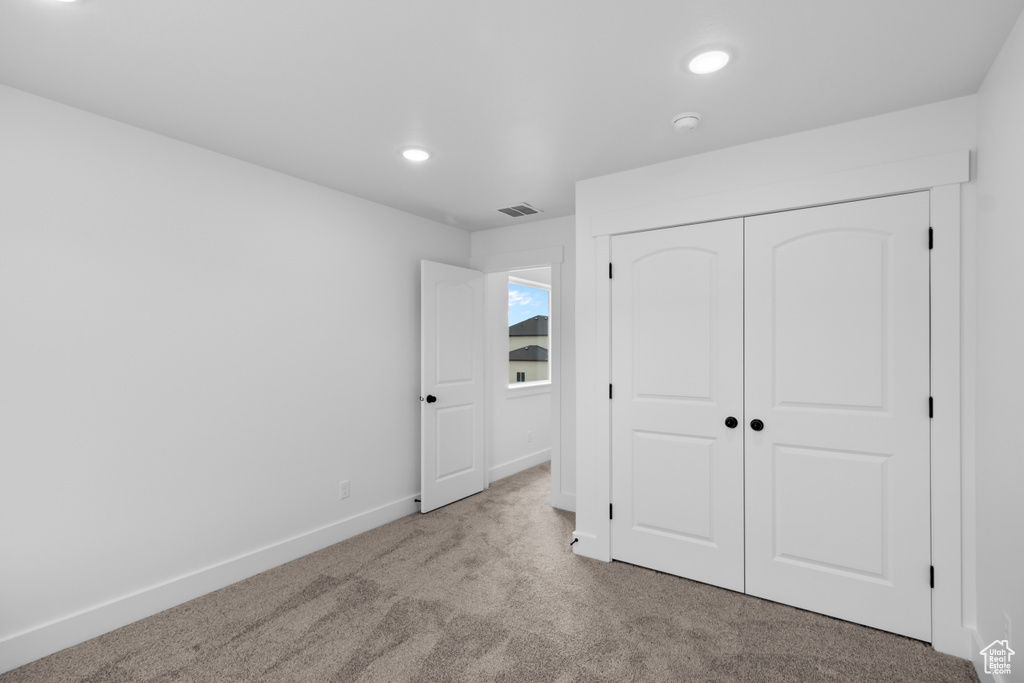 Unfurnished bedroom with carpet floors, recessed lighting, and a closet