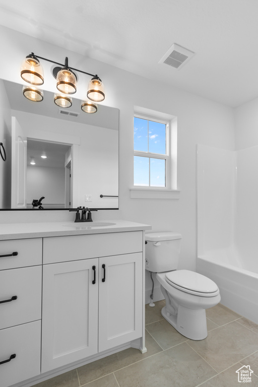 Full bath featuring vanity, tile patterned flooring, and tub / shower combination