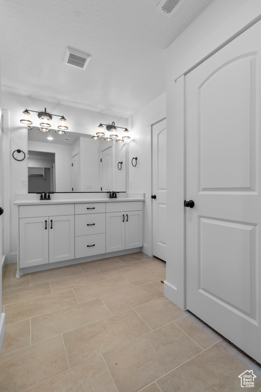 Bathroom featuring double vanity and tile patterned floors