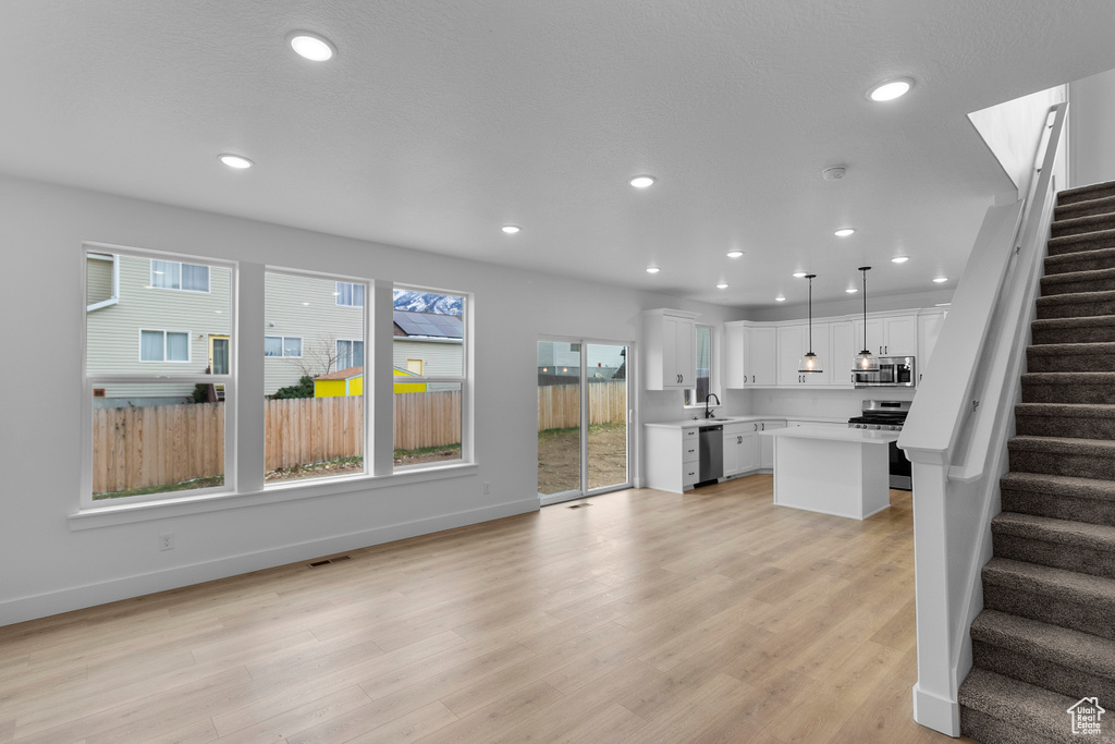 Unfurnished living room featuring stairway, recessed lighting, and light wood finished floors