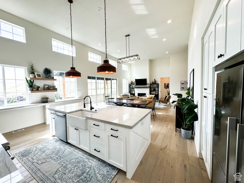 Kitchen featuring fridge, dishwasher, white cabinetry, recessed lighting, and light wood-type flooring