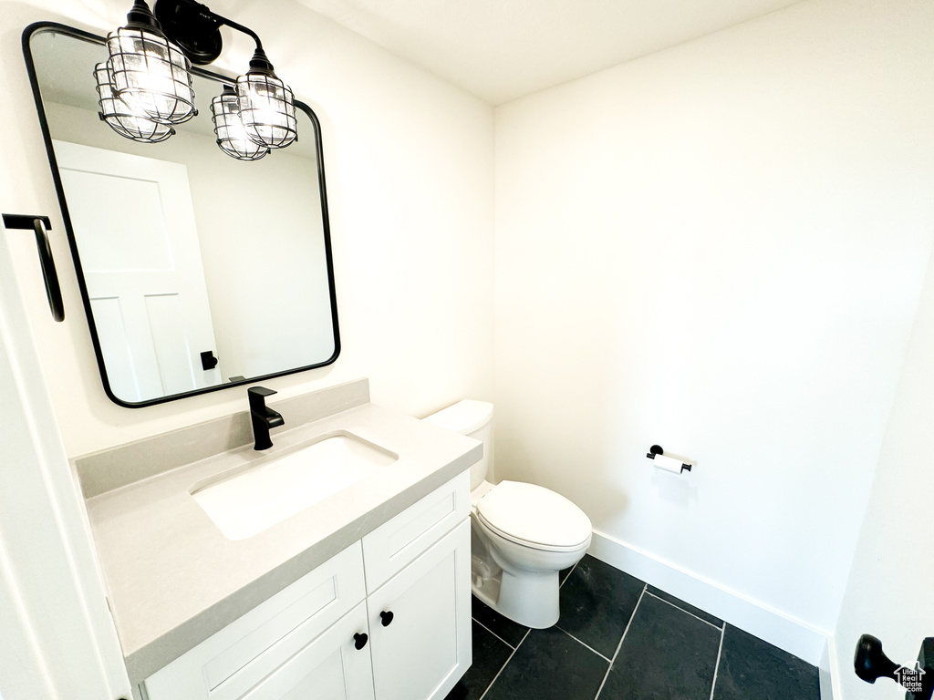 Half bathroom with tile patterned flooring and vanity