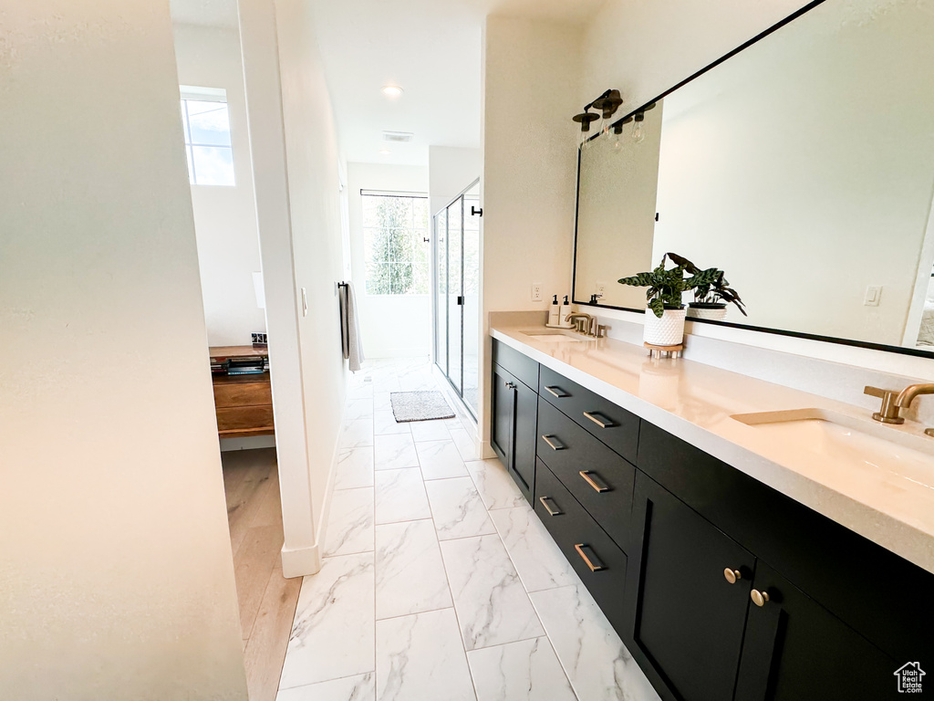 Full bathroom featuring double vanity, a stall shower, marble look tile flooring, and recessed lighting