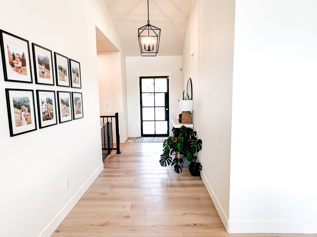Entryway featuring light wood finished floors and a chandelier