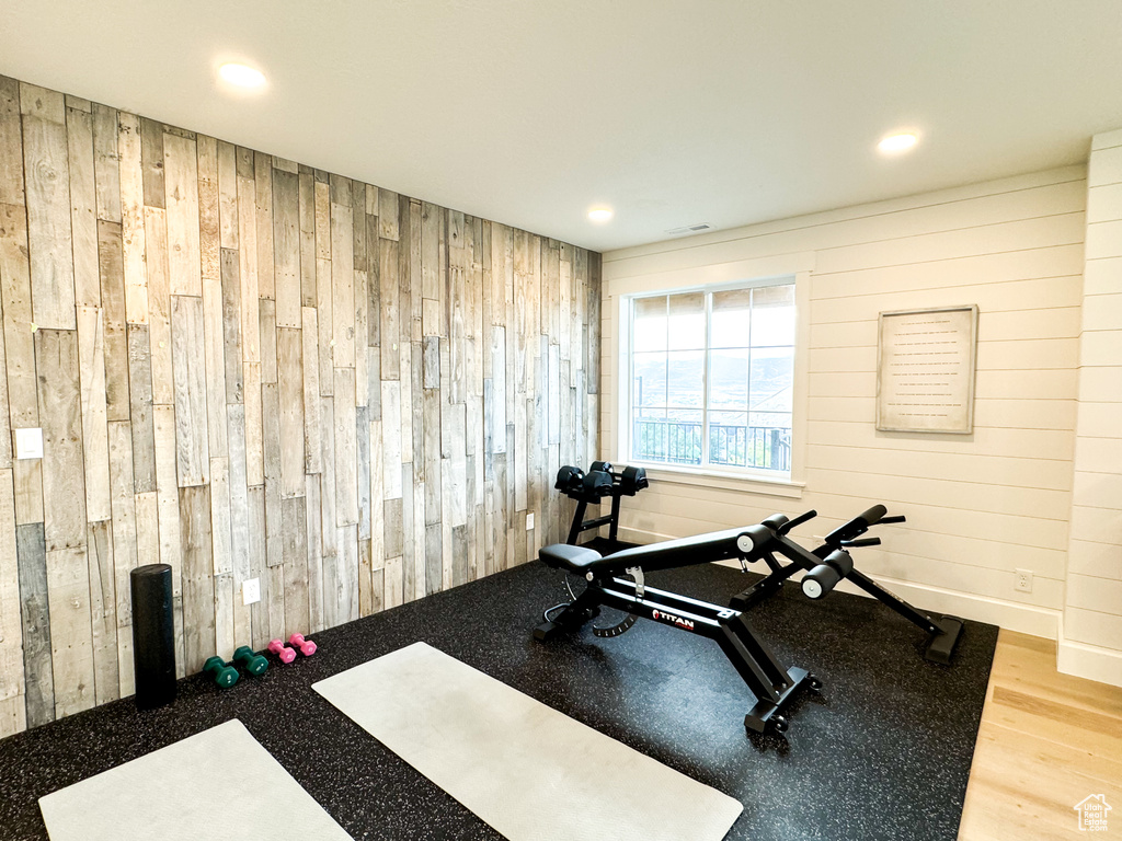 Workout room with wooden walls, recessed lighting, and wood finished floors