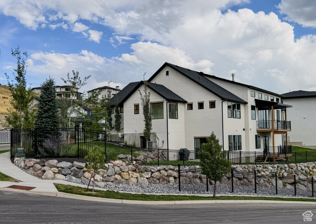 View of side of home featuring stucco siding and a balcony