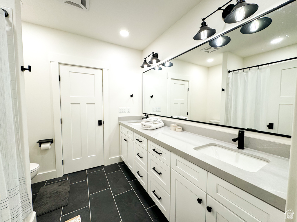 Bathroom with double vanity, tile patterned floors, recessed lighting, and curtained shower