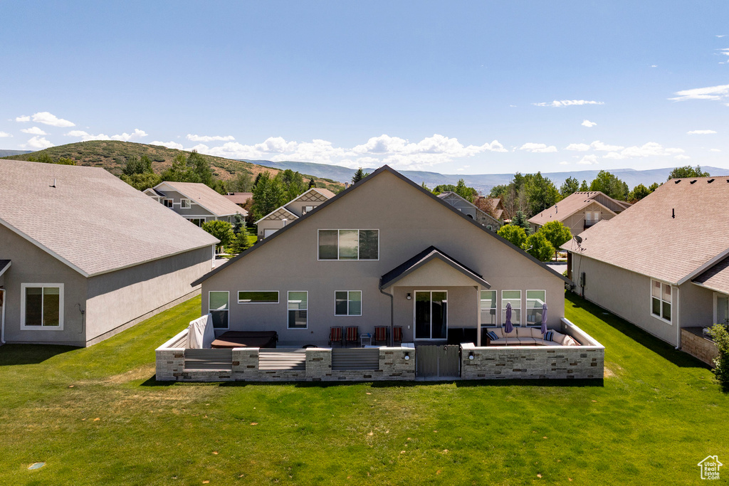 Rear view of property featuring a lawn, a residential view, and a patio
