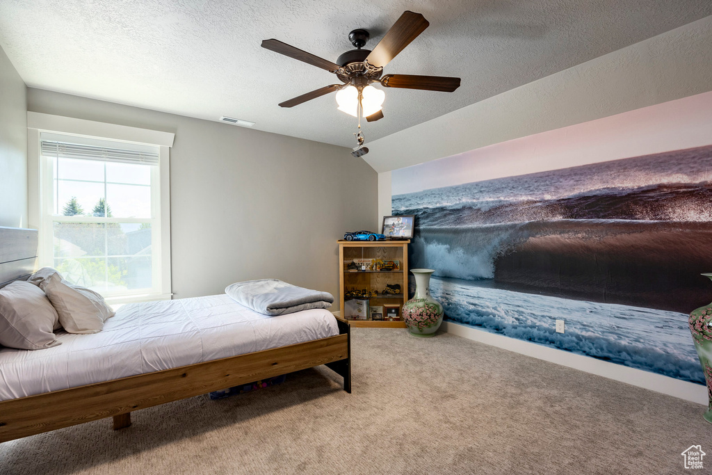 Bedroom featuring carpet flooring, a ceiling fan, and a textured ceiling