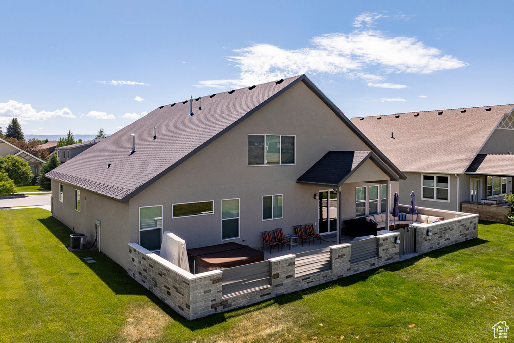 Rear view of house featuring an outdoor hangout area, a lawn, stucco siding, and roof with shingles