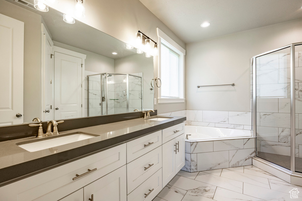 Bathroom with a marble finish shower, a garden tub, double vanity, marble finish flooring, and recessed lighting