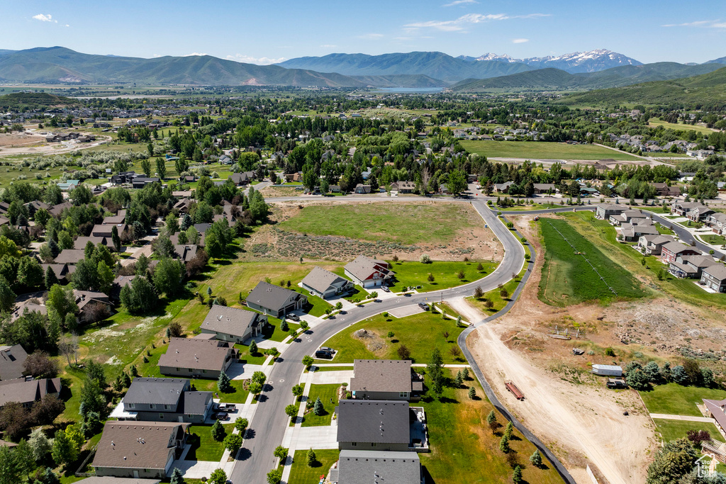 Aerial view of property's location featuring a mountain backdrop and nearby suburban area