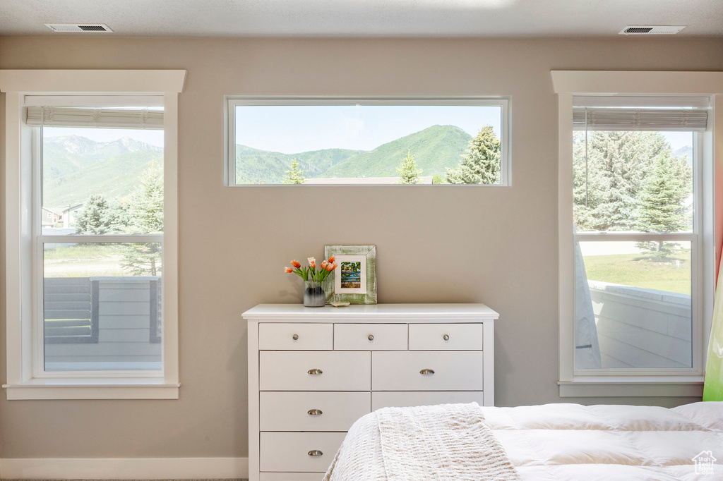 Bedroom with multiple windows and a mountain view