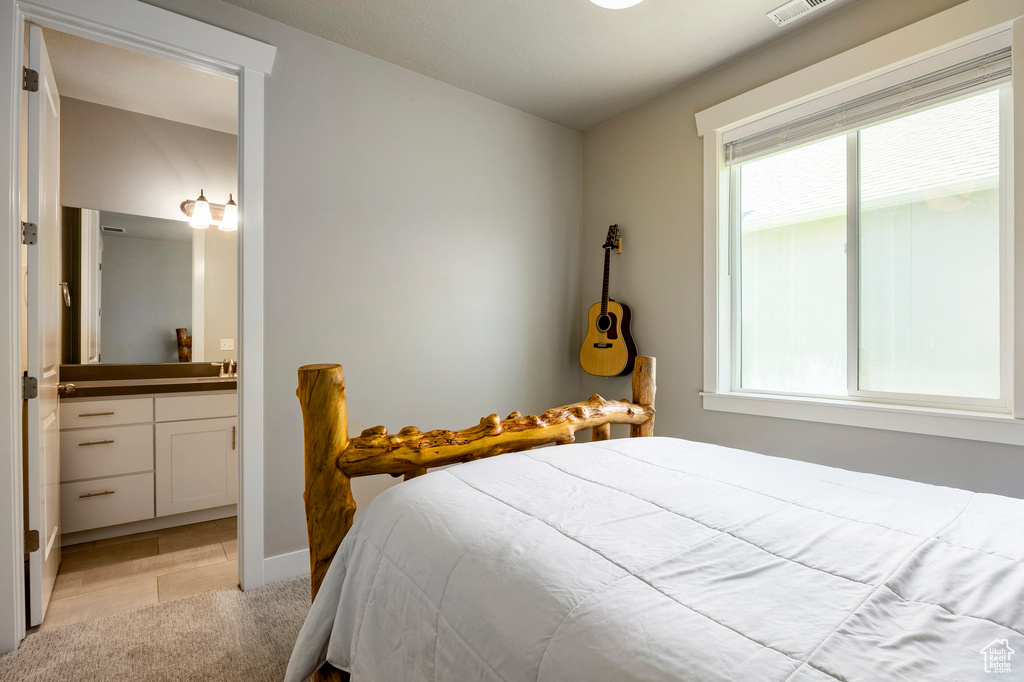 Bedroom featuring multiple windows and ensuite bath
