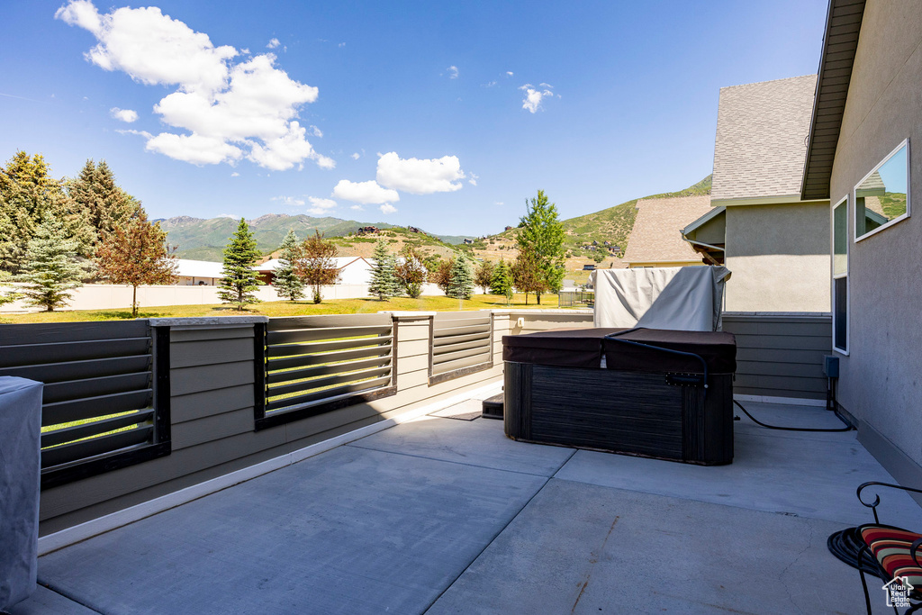View of patio featuring a hot tub and a mountain view