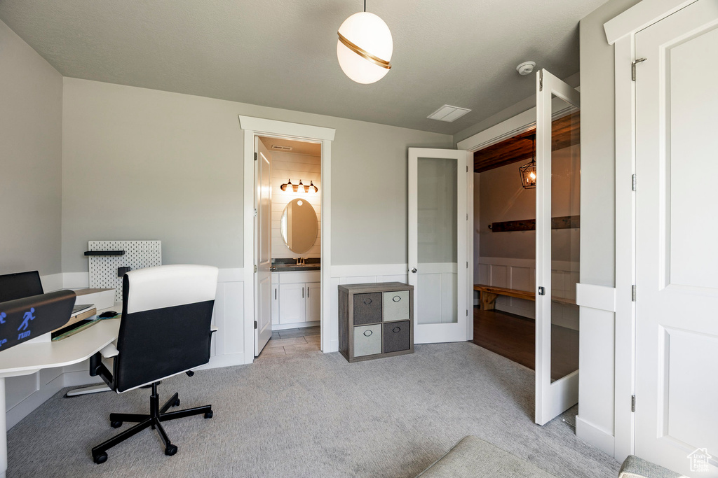 Office area with light carpet, wainscoting, and french doors