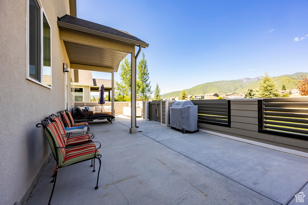 View of patio with a mountain view and area for grilling