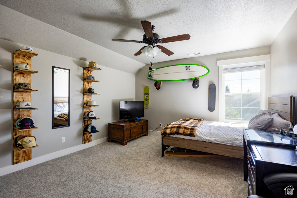 Bedroom featuring carpet, a textured ceiling, ceiling fan, and lofted ceiling