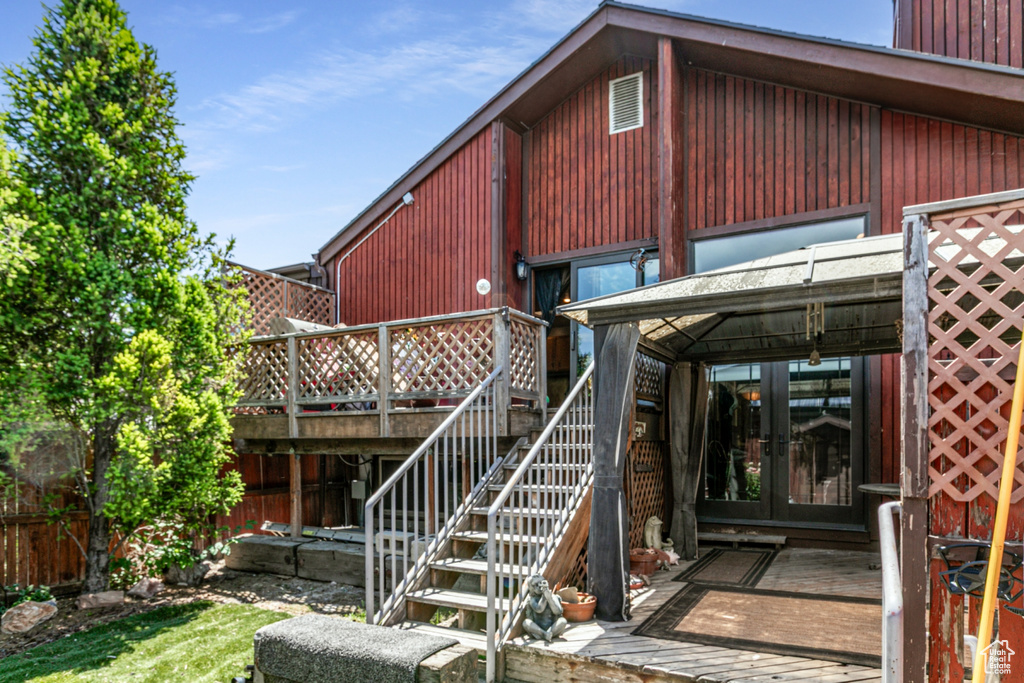 Rear view of house with french doors, a deck, and stairway