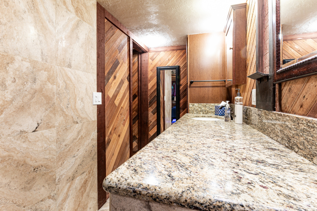 Detailed view of wooden walls, a textured ceiling, and vanity