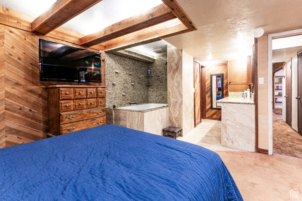 Bedroom featuring carpet flooring, a textured ceiling, and wooden walls