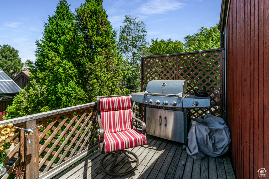 Wooden terrace featuring a grill