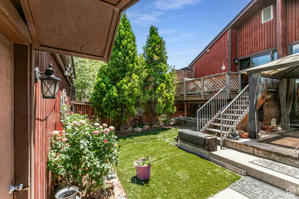 Fenced backyard featuring a wooden deck and stairway