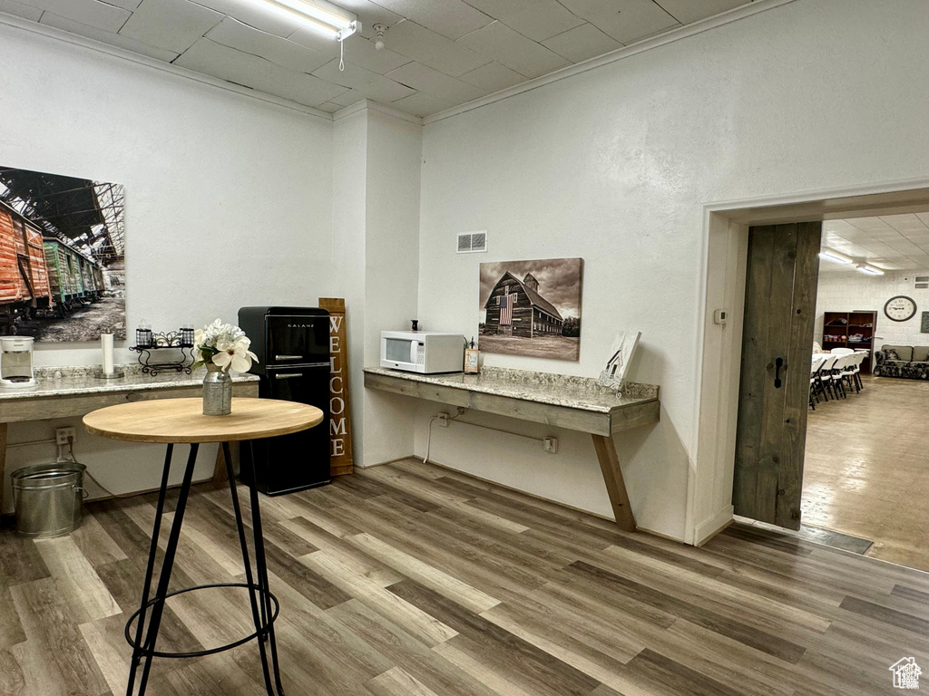 Office with wood finished floors and ornamental molding