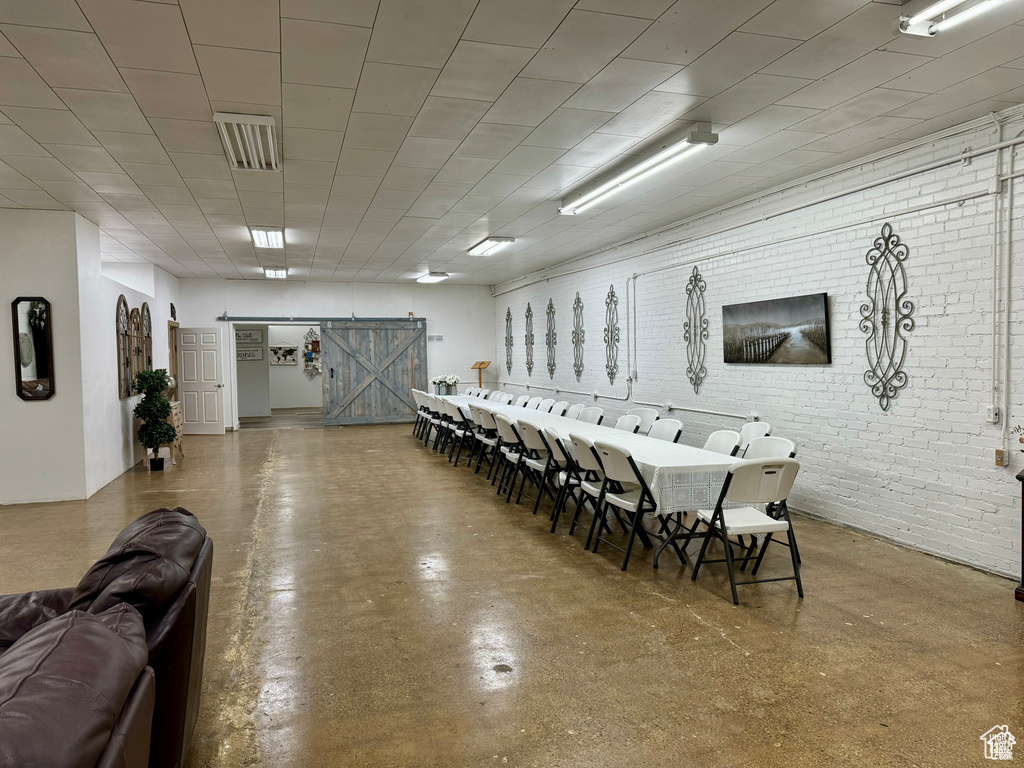 Dining space featuring a barn door and brick wall