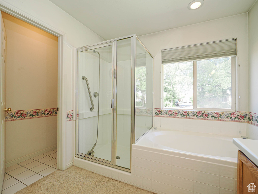 Bathroom featuring a shower stall, a bath, tile patterned flooring, and vanity