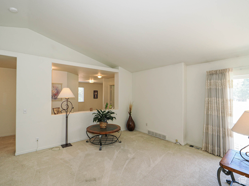 Sitting room featuring carpet flooring and lofted ceiling