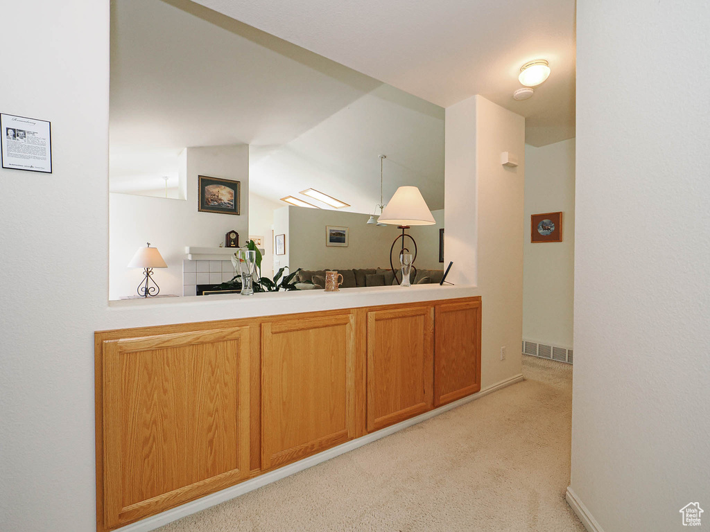 Bar featuring vaulted ceiling and light colored carpet