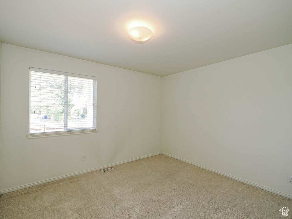 Empty room with light carpet and baseboards