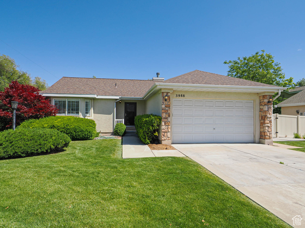 Ranch-style house featuring stone siding, concrete driveway, an attached garage, and stucco siding