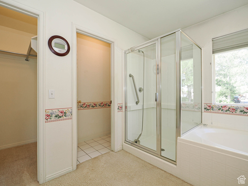 Full bath with a shower stall, a bath, tile patterned flooring, and carpet flooring