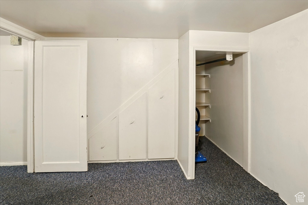 Unfurnished bedroom with dark colored carpet