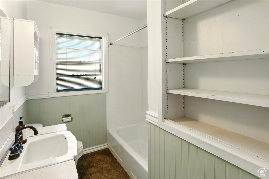 Bathroom with toilet, shower / tub combination, vanity, and baseboards