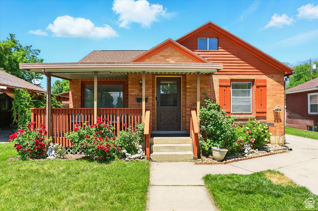 View of front of home with a porch and a front lawn