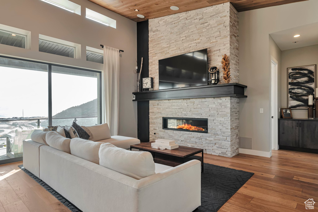 Living area with healthy amount of natural light, wood finished floors, wood ceiling, a fireplace, and recessed lighting