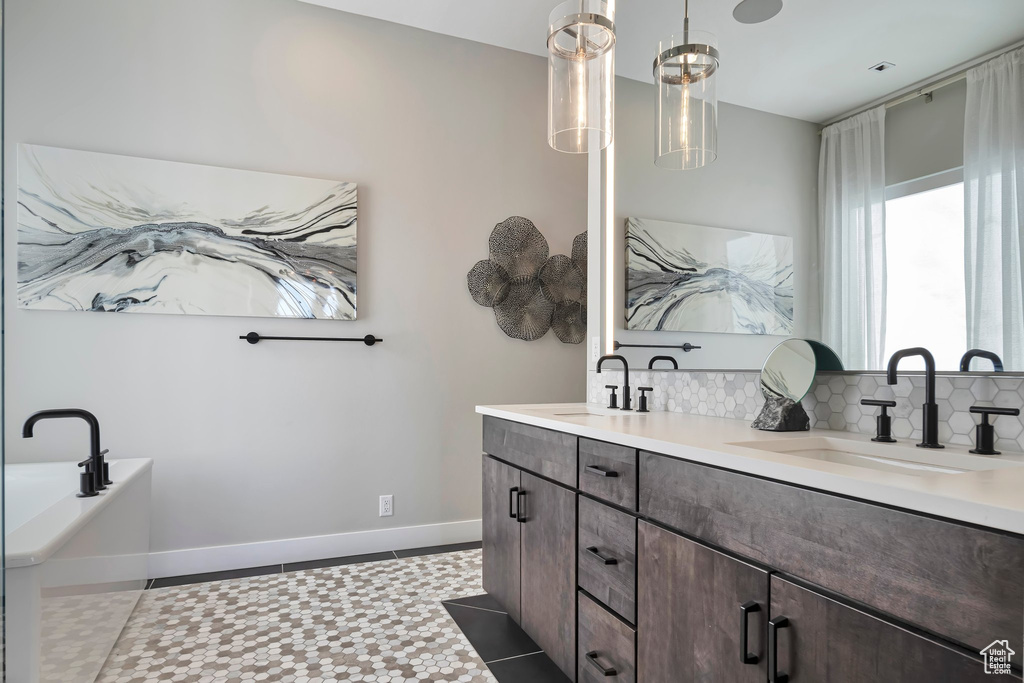 Bathroom with double vanity, a bath, and backsplash