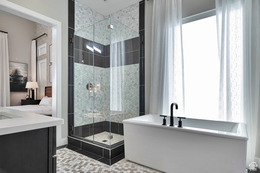 Bathroom featuring a freestanding bath, a stall shower, vanity, and ensuite bathroom