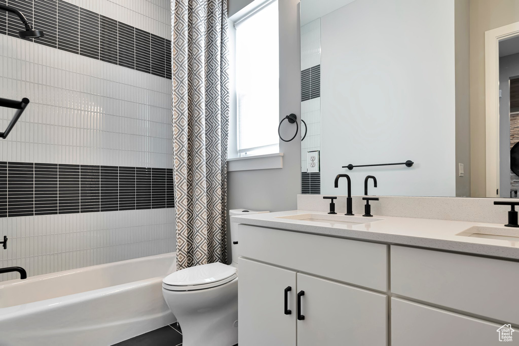 Full bathroom with shower / bath combo with shower curtain and double vanity