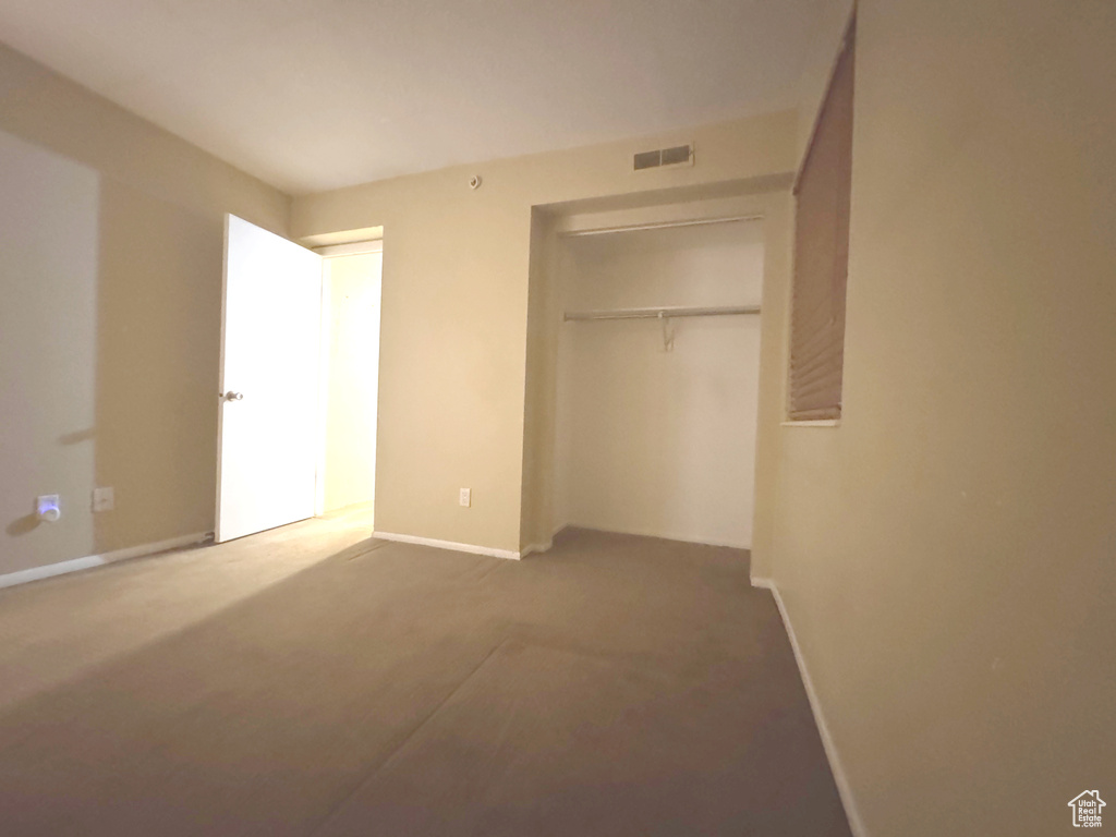 Unfurnished bedroom with a closet, carpet floors, and baseboards