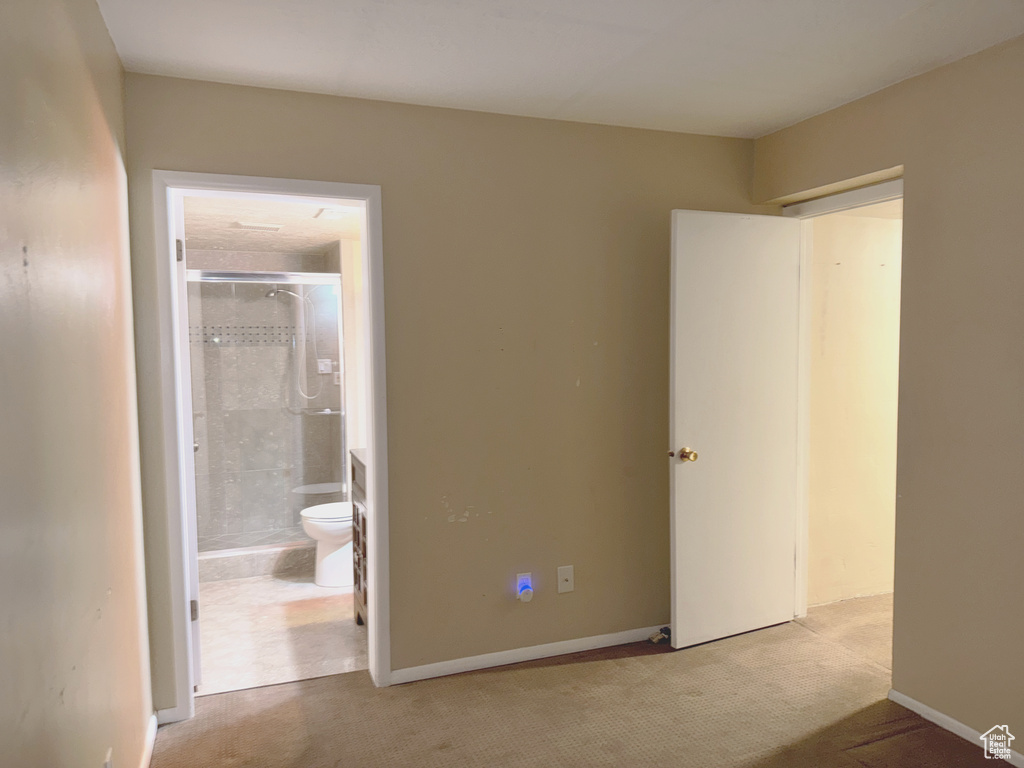 Unfurnished bedroom featuring carpet floors, connected bathroom, and baseboards